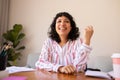 Portrait of smiling young biracial businesswoman sitting at desk in office Royalty Free Stock Photo