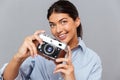 Portrait of a smiling young brunette girl holding photo camera Royalty Free Stock Photo