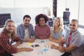 Portrait of smiling young business team sitting together at desk Royalty Free Stock Photo