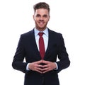 portrait of smiling young businessman standing with fingers together