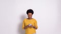 Portrait of smiling young businesswoman with afro hair texting over smart phone on white background Royalty Free Stock Photo