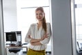 Portrait of smiling young businesswoman with arms crossed in doorway of office Royalty Free Stock Photo