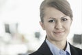 Portrait of smiling young businesswoman with bangs looking at the camera, head and shoulders