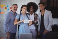 Portrait of smiling young businesswoman explaining over digital tablet to colleagues Royalty Free Stock Photo