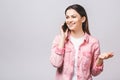 Portrait of a smiling young casual brunette woman talking on mobile phone isolated over white background Royalty Free Stock Photo