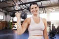 Portrait of smiling young caucasian athlete lifting dumbbell during bicep curl workout in gym. Strong, fit, active woman Royalty Free Stock Photo