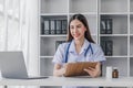 Portrait of smiling young Caucasian female doctor or nurse in white medical uniform in clinic Royalty Free Stock Photo