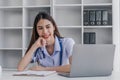 Portrait of smiling young Caucasian female doctor or nurse in white medical uniform in clinic Royalty Free Stock Photo