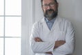 Portrait of smiling young caucasian male doctor wear white medical uniform, stethoscope and glasses look at camera posing in Royalty Free Stock Photo