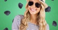 Portrait of smiling young caucasian woman wearing sunglasses and hat, headwear on green background Royalty Free Stock Photo