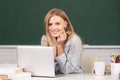 Portrait of smiling young college student studying in classroom. Creative young smiling female student using laptop. Royalty Free Stock Photo