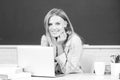 Portrait of smiling young college student studying in classroom. Creative young smiling female student using laptop. Royalty Free Stock Photo