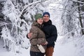 Young couple smiling while hiking in a snow covered forest