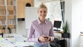 Portrait of smiling young european businesswoman with phone in hands.