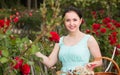 portrait of young female holding a basket near roses in outdoors Royalty Free Stock Photo
