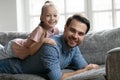 Portrait of smiling young father holding cute daughter on back. Royalty Free Stock Photo