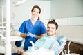 Portrait Of Smiling Dentist And Mid Adult Man In Clinic Royalty Free Stock Photo