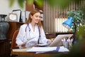 Smiling young female doctor working with laptop in office Royalty Free Stock Photo