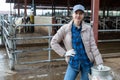 Female farmer standing near cowshed at dairy farm with milk churn Royalty Free Stock Photo