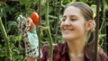 Portrait of smiling young female garden picking red ripe tomatoes in backyard garden