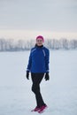 Portrait of a smiling young female sportswoman in winter ice field