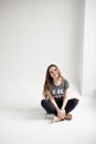 Portrait of a smiling young girl sitting with legs crossed isolated on white background Royalty Free Stock Photo