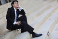 Portrait of smiling young handsome businessman sitting on the stairs Royalty Free Stock Photo