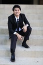 Portrait of smiling young handsome businessman sitting on the stairs Royalty Free Stock Photo