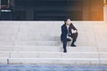 Portrait of smiling young handsome businessman sitting on the stairs Royalty Free Stock Photo