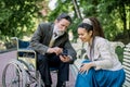 Portrait of smiling young hipster woman with long dreadlocks, sitting on the bench in park, enjoying time with her Royalty Free Stock Photo