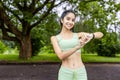 Portrait of a smiling young Indian woman in sportswear jogging, standing in a park, checking the time on a smart watch Royalty Free Stock Photo