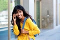 Smiling young Indian woman walking and talking with mobile phone Royalty Free Stock Photo