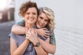 Smiling young lesbian couple standing affectionately together outdoors