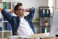 Portrait Of Smiling Young Male Entrepreneur Relaxing At Workplace In Office