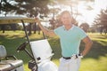 Portrait of smiling young man by golf buggy Royalty Free Stock Photo