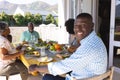 Portrait of smiling young man having lunch with multiracial multigeneration family at dining table Royalty Free Stock Photo