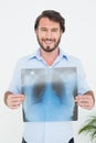 Portrait of a smiling young man holding lung xray Royalty Free Stock Photo