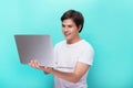 Portrait of smiling young man with laptop isolated on blue. Royalty Free Stock Photo