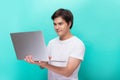 Portrait of smiling young man with laptop isolated on blue Royalty Free Stock Photo