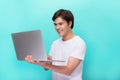 Portrait of smiling young man with laptop isolated on blue. Royalty Free Stock Photo
