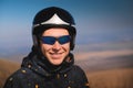 Portrait of a smiling young man with a parachute in a field. A guy paraglider in sportswear and a helmet is preparing