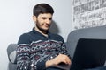 Portrait of smiling young man, sitting on sofa home and using laptop. Royalty Free Stock Photo