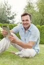 Portrait of smiling young man using tablet computer in park Royalty Free Stock Photo