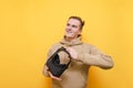 Portrait of a smiling young man with VR helmet in his hands on a yellow background, looking away at copy space. Happy guy with Royalty Free Stock Photo