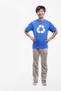 Portrait of smiling young man wearing recycling symbol T-shirt with hands on his hips, studio shot Royalty Free Stock Photo