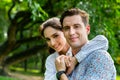 Portrait smiling young man and woman couple in love hugging in the park at summer season with warm sunlight. people and lifestyle Royalty Free Stock Photo