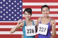 Portrait of smiling young medalists standing against Chinese flag Royalty Free Stock Photo