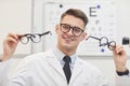 Smiling Ophthalmologist Holding Glasses