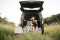 Portrait of smiling young parents embarrassing their little daughter and dog with delicious pizza. Royalty Free Stock Photo