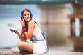 Smiling young urban woman using smart phone outdoors while waiting for her friends Royalty Free Stock Photo